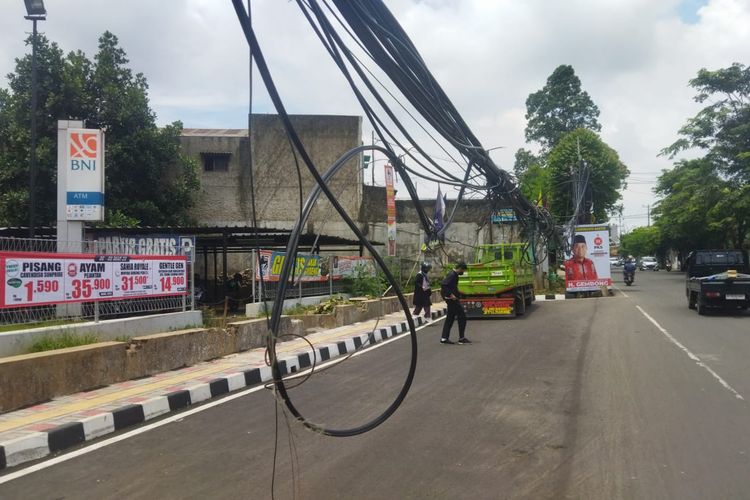 Warga di sekitar Jalan Hasyim Ashari, Kecamatan Pinang, Kota Tangerang mengeluhkan kabel semrawut yang menjuntai di tengah jalan raya di titik lokasi tersebut. Berdasarkan pantauan Kompas.com pada Senin (13/3/2023) pagi menjelang siang, kabel tersebut tampai menjuntai dengan jarak ketinggian dari tanah hanya sekitar 100-150 sentimeter saja.