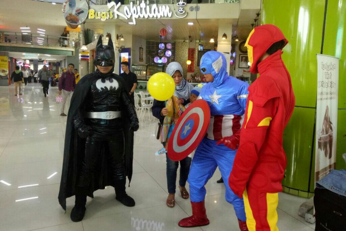 Super hero sedang membagikan balon kepada anak kecil di Stasiun Gambir Jakarta Pusat.
