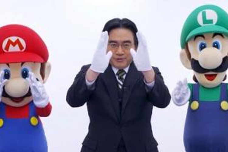 Satoru Iwata dengan maskot Nintendo, Mario dan Luigi dari game Mario Bros.