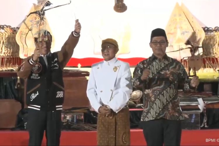 Presiden Jokowi lalu menerima sebuah wayang dari sang dalang Ki Manteb Soedharsono, dalam pagelaran wayang di halaman Istana Merdeka, Jakarta, Jumat (2/8/2019).. Jokowi yang mengenakan jaket bomber berwarna biru sempat memainkan wayang tersebut. 