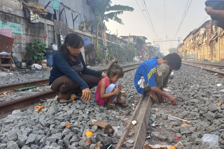 Seorang ibu rumah tangga bernama Warni (38) tengah menjaga anaknya yang sedang bermain di pinggir rel kereta api di Gang 21, Jalan Pademangan V, RT 09/RW 10, Pademangan Barat, Pademangan, Jakarta Utara.  