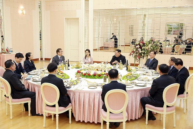 Pemimpin Korea Utara Kim Jong Un (kanan tengah) berbicara dengan delegasi Korea Selatan saat makan malam di Pyongyang, Korea Utara, Senin (5/3/2018). (KCNA via AFP)