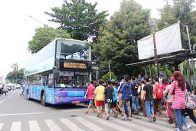 Wisatawan menyerbu kedatangan bus Wisata Jakarta yang beroprasi di Kota Tua, Minggu (5/6/2016).