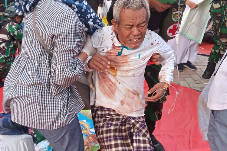 Seorang warga korban gempa Cianjur, Jawa Barat, dibopong untuk menjalani penanganan medis di rumah sakit, Senin (21/11/2022) petang.