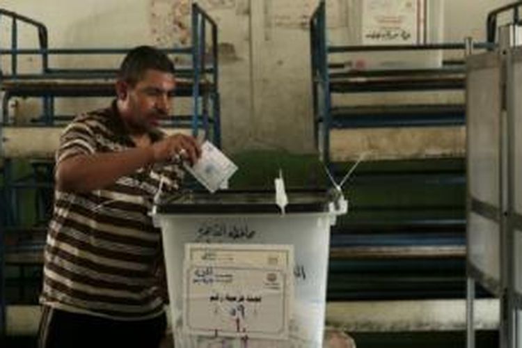 Seorang warga Mesir memberikan suaranya dalam pemilihan umum di Kairo, Mei 2014. 