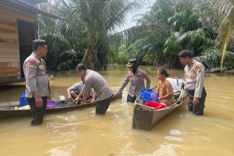 Petugas kepolisian menggunakan sampan untuk mengantarkan bantuan sembako kepada warga yang terdampak banjir, di Desa Petapahan, Kecamatan Tapung, Kabupaten Kampar, Riau, Rabu (31/1/2024).
