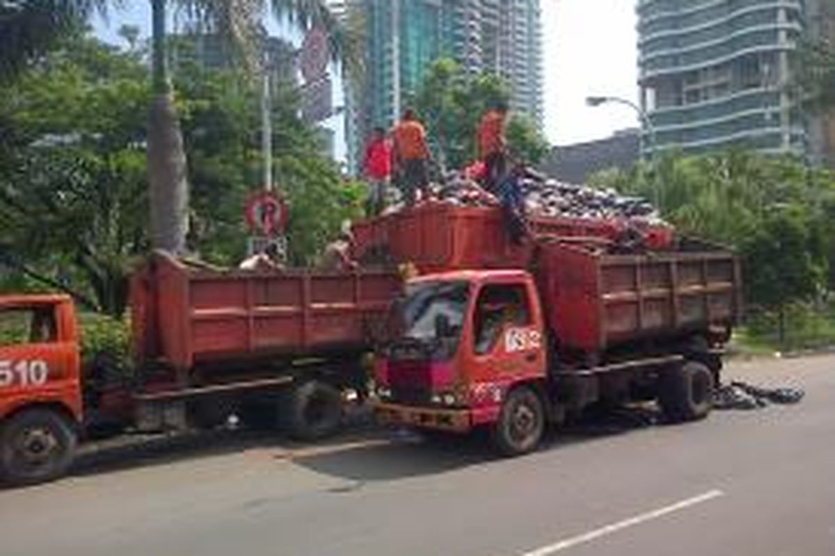Dua truk pengangkut sampah dikerahkan untuk mengakut sampah yang berada di pinggir jalan kawasan Kembangan, Jakarta Barat