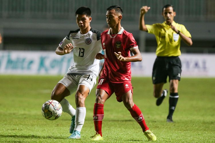 Pemain timnas U17 Indonesia Riski Afrizal (kanan) berebut bola dengan pemain timnas U17 Guam  Nicholas Moore pada pertandingan Kualifikasi Piala Asia U17 2023 di Stadion Pakansari, Kabupaten Bogor, Senin (3/10/2022).  Indonesia menang 14-0 atas Guam.