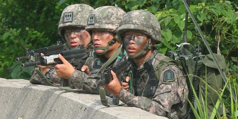 Para prajurit Korea Selatan ini berlindung di balik pembatas jalan saat mengepung tersangka pelaku penembakan lima tentara di sebuah kawasan hutan di wilayah timur negeri itu. Setelah dikepung selama 24 jam, pelaku penembakan bisa diringkus.