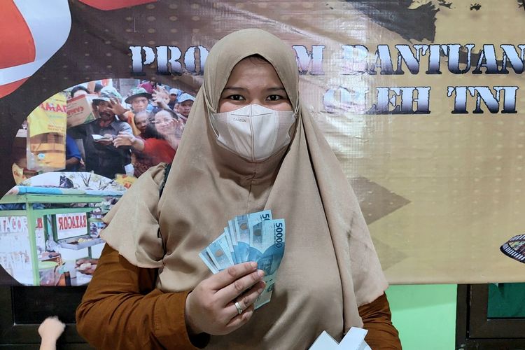 Seorang warga menerima Bantuan Langsung Tunai Pangan Minyak Goreng di Koramil Kebon Jeruk, Jakarta Barat, Rabu (18/5/2022). 
