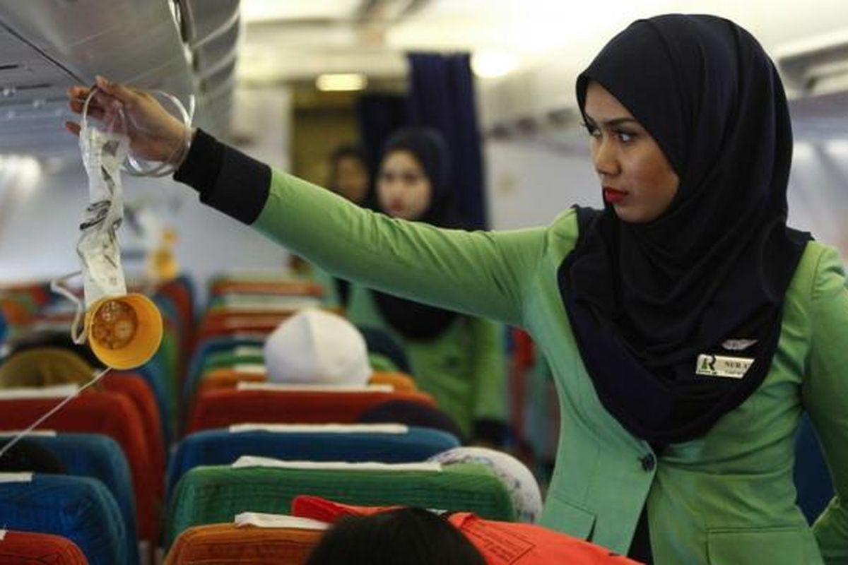 Dalam foto bertanggal 22 Desember 2015, seorang pramugari Rayani Air tengah menyiapkan kesiapan kabin sebelum penerbangan dari bandara Sultan Ismail Petra, di Kelantan, Malaysia.