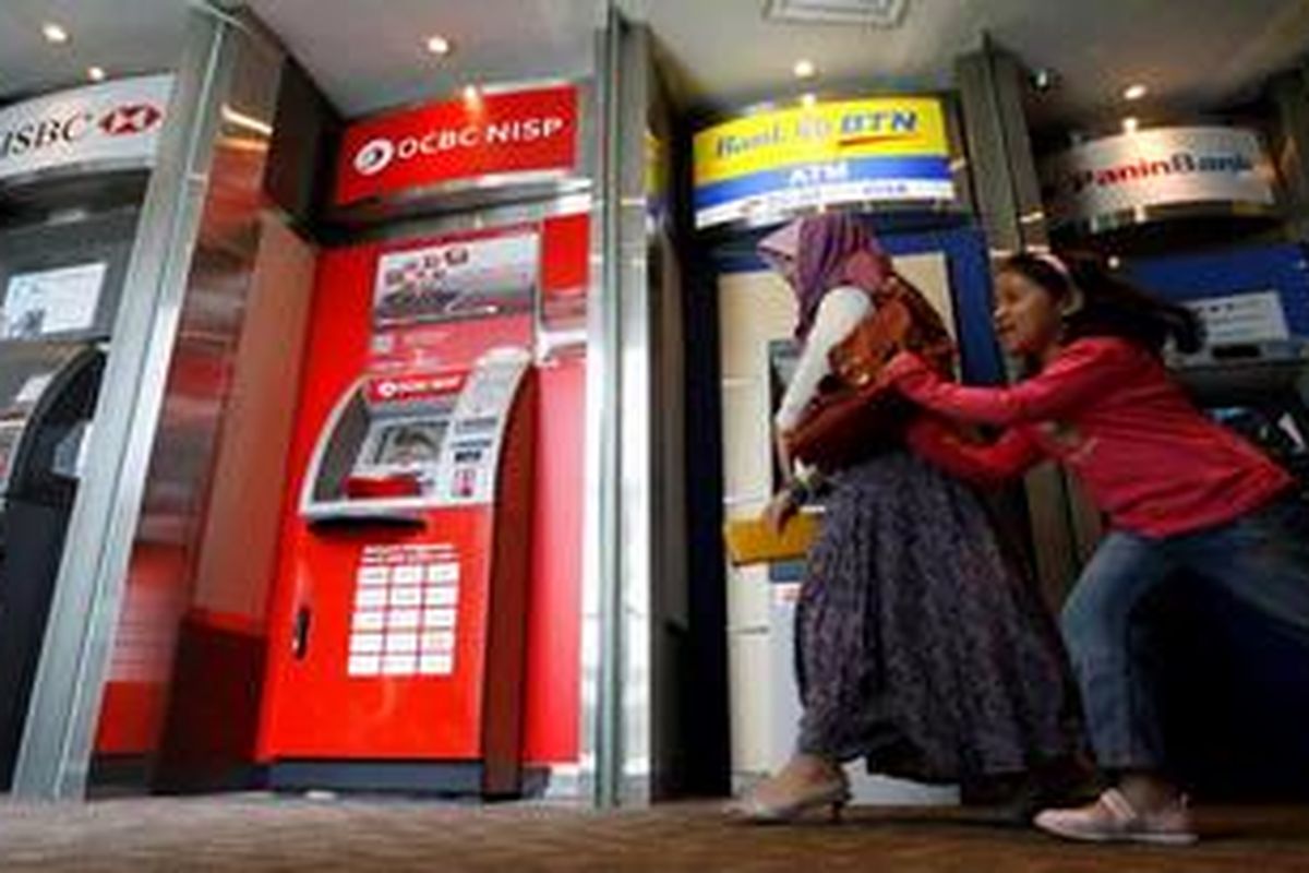 Nasabah seusai melakukan transaksi melalui anjungan tunai mandiri (ATM) di Pusta Perbelanjaan Grand Indonesia, Jakarta Pusat, Senin (6/5/2013). Penandatanganan nota kesepahaman antara tiga operator ATM (prinsipal) yaitu PT. Artajasa Pembayaran Elektronik (ATM Bersama), PT. Rintis Sejahtera (ATM Prima), dan PT. Alto Network (ALTO) akan mempermudah nasabah perbankan untuk melakukan transfer dana ke bank mana pun melalui ATM yang mulai efektif Juli 2013. 
