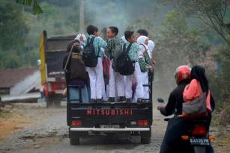 Pelajar menaiki mobil bak terbuka di Dusun Tretepan, Desa Pandansari, Paguyangan, Brebes, Jawa Tengah,  Selasa (16/9/2014). Mobil bak terbuka merupakan alat transportasi utama bagi warga di lereng Gunung Slamet tersebut.