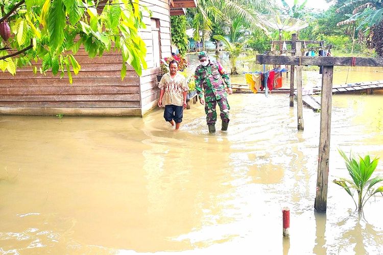 Babinsa Koramil 10/Kunto Darussalam, Koptu Yuliarno memantau aktivitas warga di tengah banjir di Desa Sontang, Kecamatan Bonai Darussalam, Kabupaten Rohul, Riau, Kamis (26/11/2020).