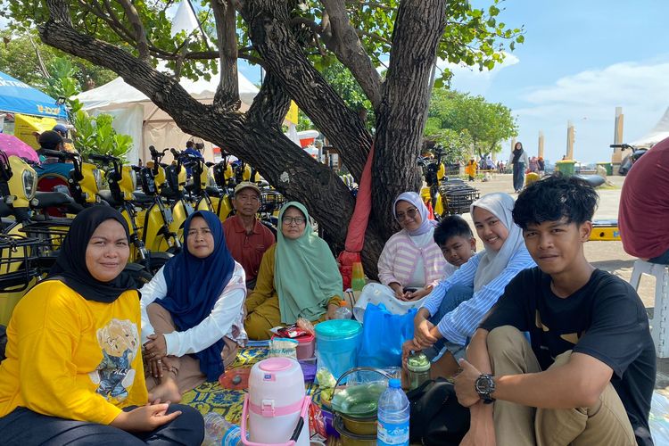 Ria (37) dan keluarga asal Bekasi Barat yang berkunjung ke Pantai Ancol, Jakarta Utara, Senin (15/4/2024).