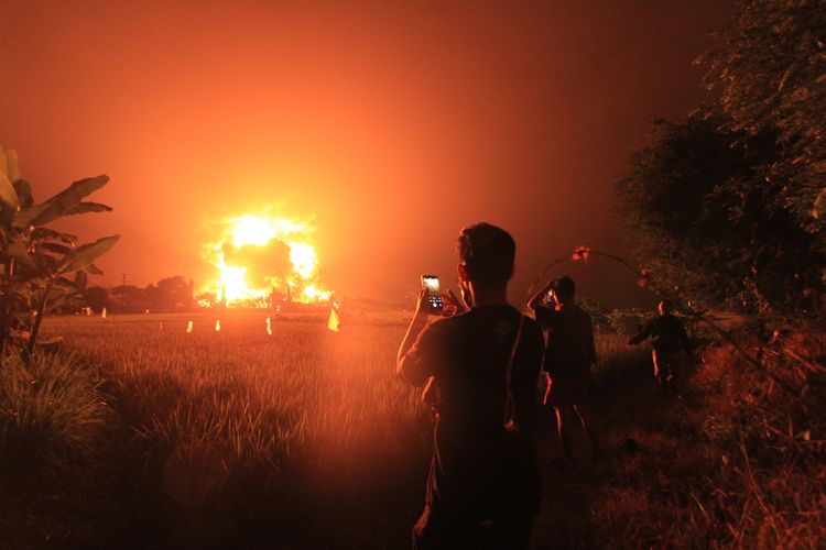 Warga menyaksikan kebakaran di kompleks Pertamina RU VI Balongan, Indramayu, Jawa Barat, Senin (29/3/2021) dini hari. 
