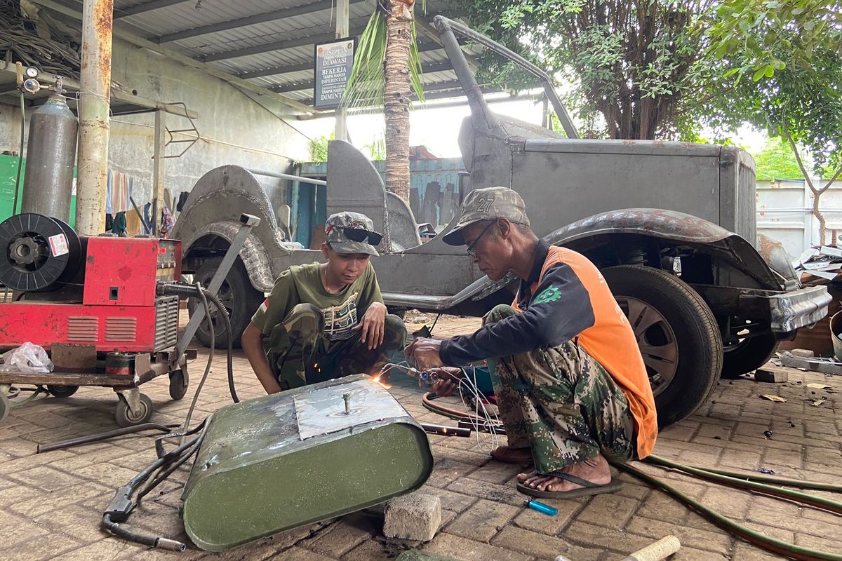 Pegawai PT Inti Maju Cemerlang mengelas body mobil bekas untuk dibuat mobil klasik.