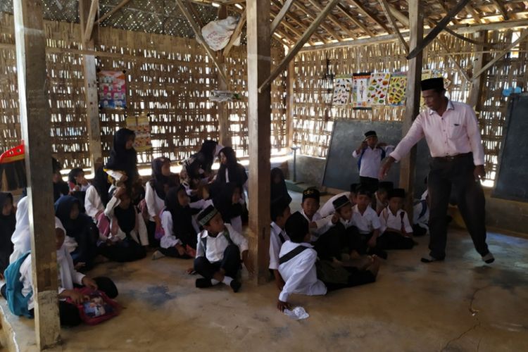 Murid-murid MI Misbahussudur, Desa Banyupelle, Kecamatan Palengaan, Kabupaten Pamekasan belajar di kelas yang terbuat dari kayu dan gedek yang sudah reot, Senin (23/9/2019). Ada pula yang belajar di pinggir kuburan umum desa setempat karena ruang kelas tidak cukup.