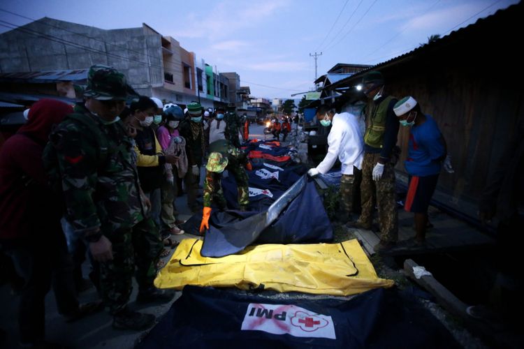 Warga mengidentifikasi jenasah korban gempa yang ditemukan di Perumnas Balaroa, Palu, Sulawesi Tengah, Sabtu (6/10/2018). Gempa bumi Palu dan Donggala bermagnitudo 7,4 mengakibatkan sedikitnya 925 orang meninggal dunia dan 65.733 bangunan rusak.