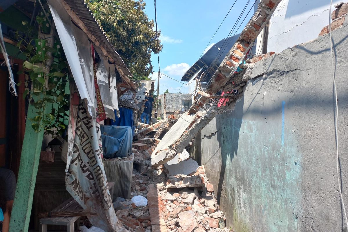 Tembok pembatas Gudang JNE di Jalan Pekapuran, Curug, Cimanggis, Depok, ambruk saat kobaran api membakar area tersebut, pada Senin (12/9/2022). Akibatnya, akses jalan warga sekitar terputus.