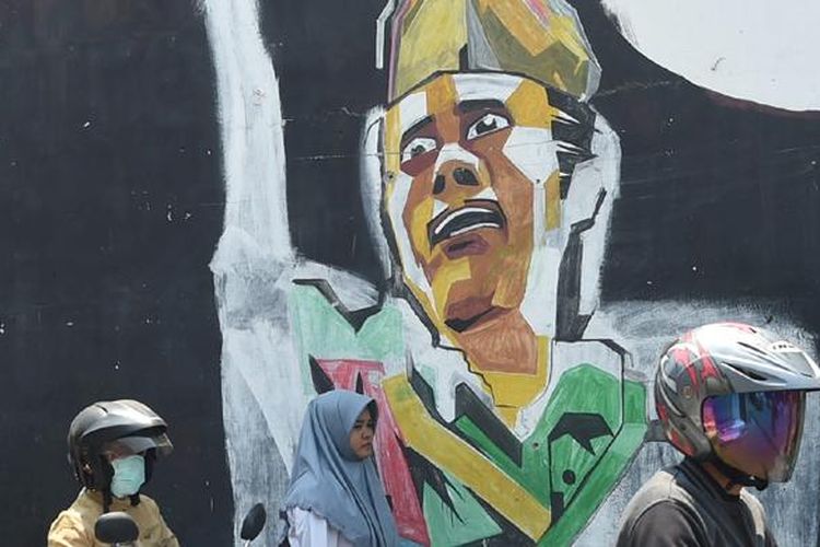 Pengendara melintasi mural bergambar Bung Tomo di Kecamatan Waru, Sidoarjo, Jawa Timur, Selasa (3/11/15). Bung Tomo menjadi ikon perlawanan arek-arek Suroboyo dalam pertempuran 10 Nomber 1945 yang kemudian dikenang sebagai Hari Pahlawan. 