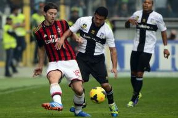 Gelandang AC Milan, Riccardo Montolivo (kanan), mendapat pengawalan dari gelandang Parma, Walter Gargano (tengah), pada laga di Stadion Ennio Tardini, Parma, Minggu (27/10/2013).