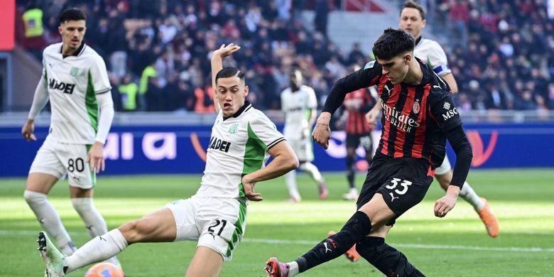 Jay Idzes (kiri) mencoba membendung tembakan Davide Bartesaghi (kanan) dalam laga Liga Italia 2025-2026 AC Milan vs Sassuolo di Stadion San Siro, 14 Desember 2025. (Photo by Piero CRUCIATTI / AFP)