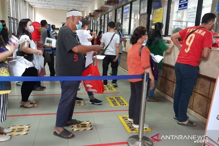 Masyarakat mengantre untuk mengurus dokumen pajak kendaraan dengan menerapkan protokol kesehatan guna mengantisipasi penyebaran COVID-19 di Kantor Satuan Administrasi Manunggal Satu Atap (Samsat) Jakarta Timur, Senin (14/12/2020). 