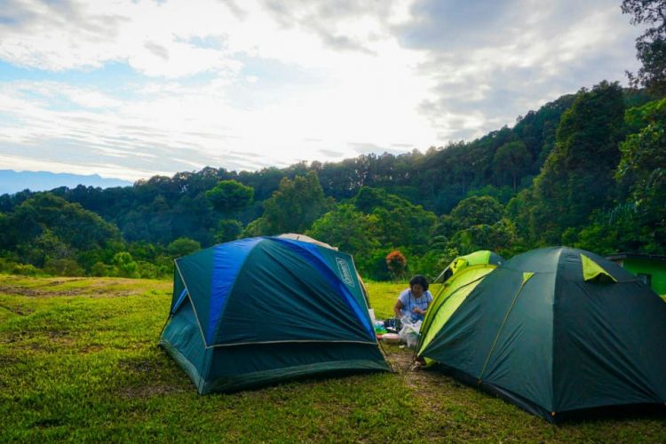 Pengunjung Bumi Perkemahan Sukamantri, Bogor, Jawa Barat, sedang menikmati suasana pagi di sekitar tenda.