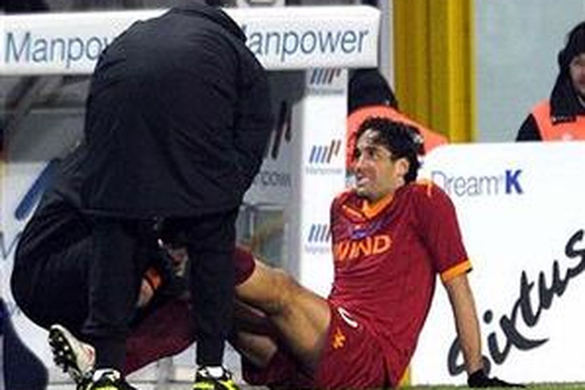 Striker AS Roma, Luca Toni, cedera saat membela timnya melawan Juventus.