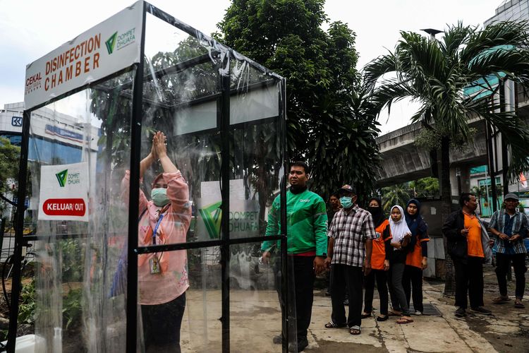 Warga saat menggunakan bilik sterilisasi (Body Chamber) di Pasar Raya Blok M, Jakarta Selatan, Selasa (24/3/2020). Dompet Dhuafa membuat 1000 unit bilik sterilisasi (Body Chamber) yang berfungsi untuk sterilisasi mencegah COVID-19 dan akan di salurkan ke berbagai fasilitas umum di wilayah Jabodetabek.