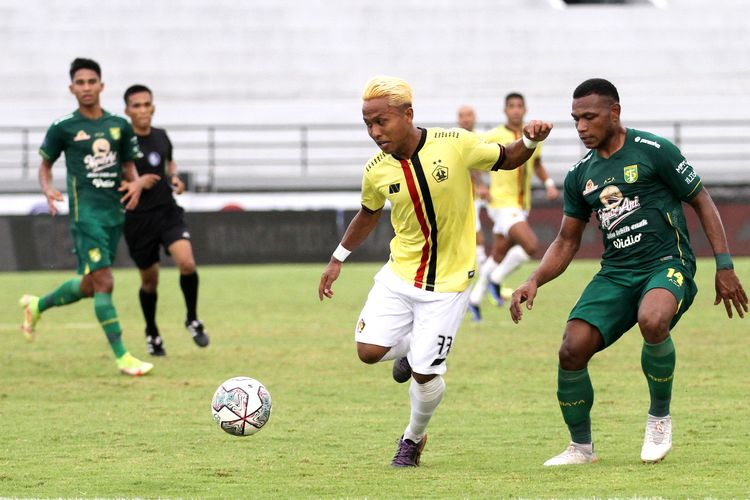 Pemain Persik Kediri Fahmi Al Ayyubi dijaga ketat pemain Persebaya Surabaya saat pertandingan pekan 30 Liga 1 2021-2022 yang berakhir dengan skor 1-0 di Stadion Kapten I Wayan Dipta Gianyar, Kamis (10/3/2022) sore.