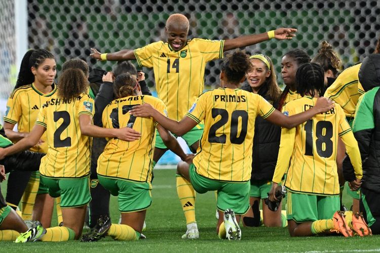 Para pemain timnas wanita Jamaika merayakan keberhasilan lolos ke fase gugur Piala Dunia Wanita 2023 yang diselenggarakan di Australia dan Selandia Baru. Pada babak 16 besar, Jamaika akan melawan Kolombia di Stadion AAMI Park, Melbourne, pada Selasa (8/8/2023) sore WIB. (Foto oleh WILLIAM WEST/AFP)