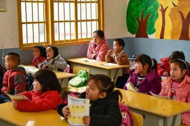 Shi Xiaoqin (31) duduk di bangku paling belakang menyimak pelajaran yang diberikan guru di dalam kelas.