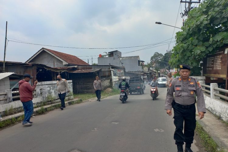 Anggota Kepolisian Sektor Bojongsari saat menunjukkan lokasi pembacokan pengendaraa motor oleh orang tak dikenal di Jalan Pondok Petir, Bojongsari, Depok, pada Kamis (16/3/2023).