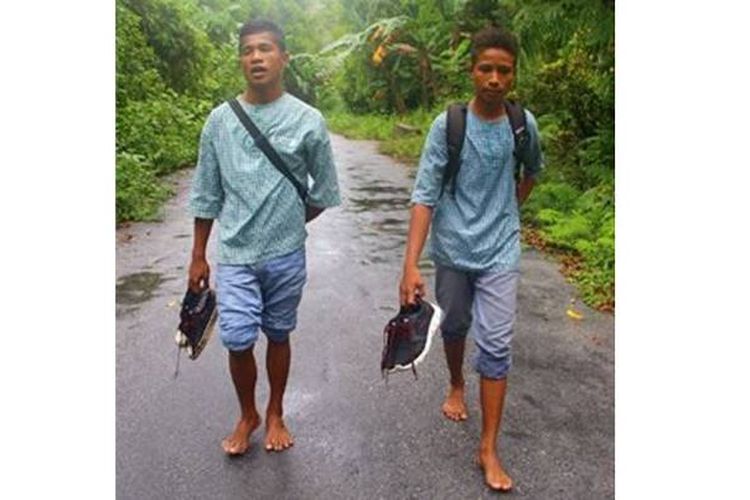 Siswa Sekolah Menengah Atas Negeri 1 Nusalaut di Pulau Nusalaut, Kabupaten Maluku Tengah, Maluku, berjalan kaki di bawah gerimis dari sekolah ke rumah seperti pada Kamis (6/4). Banyak sisiwa berjalan kaki dari rumah ke sekolah dengan jarak antara 3 kilometer (km) hingga 7 km.