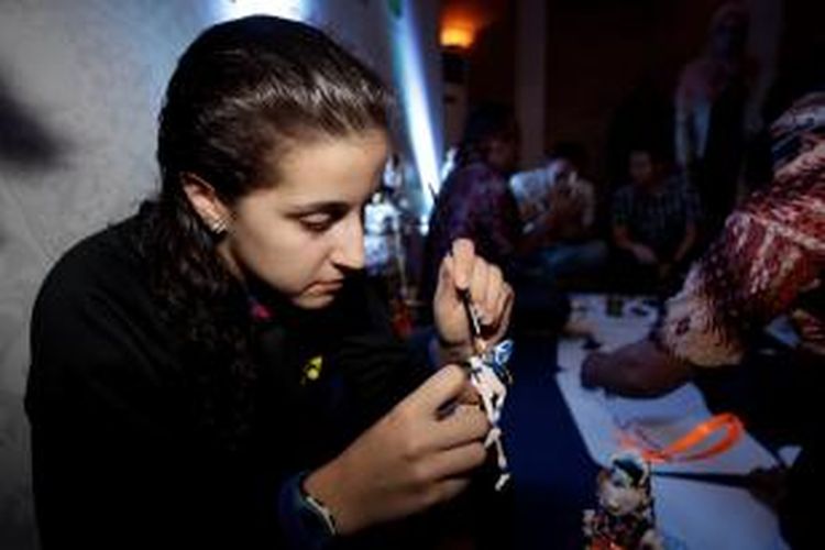 Pebulu tangkis Spanyol, Carolina Marin, menghias wayang golek mini pada acara welcome dinner jelang BCA Indonesia Open Superseries Premier di Hotel Sultan Jakarta, Senin (16/6/2014).