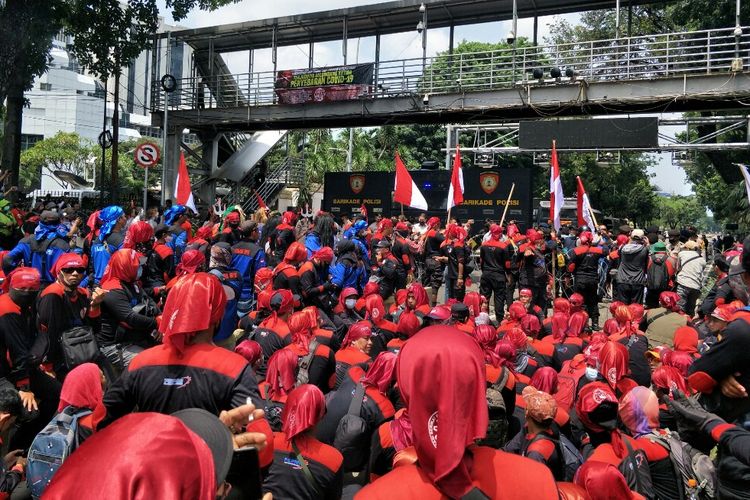 Massa buruh yang semula menggelar aksi unjuk rasa di Monas mulai bergeser memasuki Jalan Medan Merdeka Barat, Jakarta, Rabu (8/12/2021) pukul 12.10 WIB. Mereka memaksa terobos penjagaan demi mendekat ke gedung Mahkamah Konstitusi (MK).