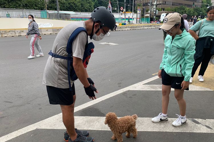 Jhony warga asal Bekasi, Jawa Barat, membawa anjing peliharaannya bernama Jo ke area Hari Bebas Kendaraan Bermotor (HBKB) atau car free day di Jalan MH Thamrin, Jakarta Pusat, Minggu (6/11/2022).