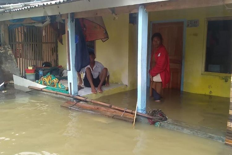 Warga tengah beraktivitas di sela banjir yang melanda Desa Karangligar, Kabupaten Karawang, Kamis (2/1/2019) pagi. Meski pada sore ini mulai surut, warga tetap diminta waspada.