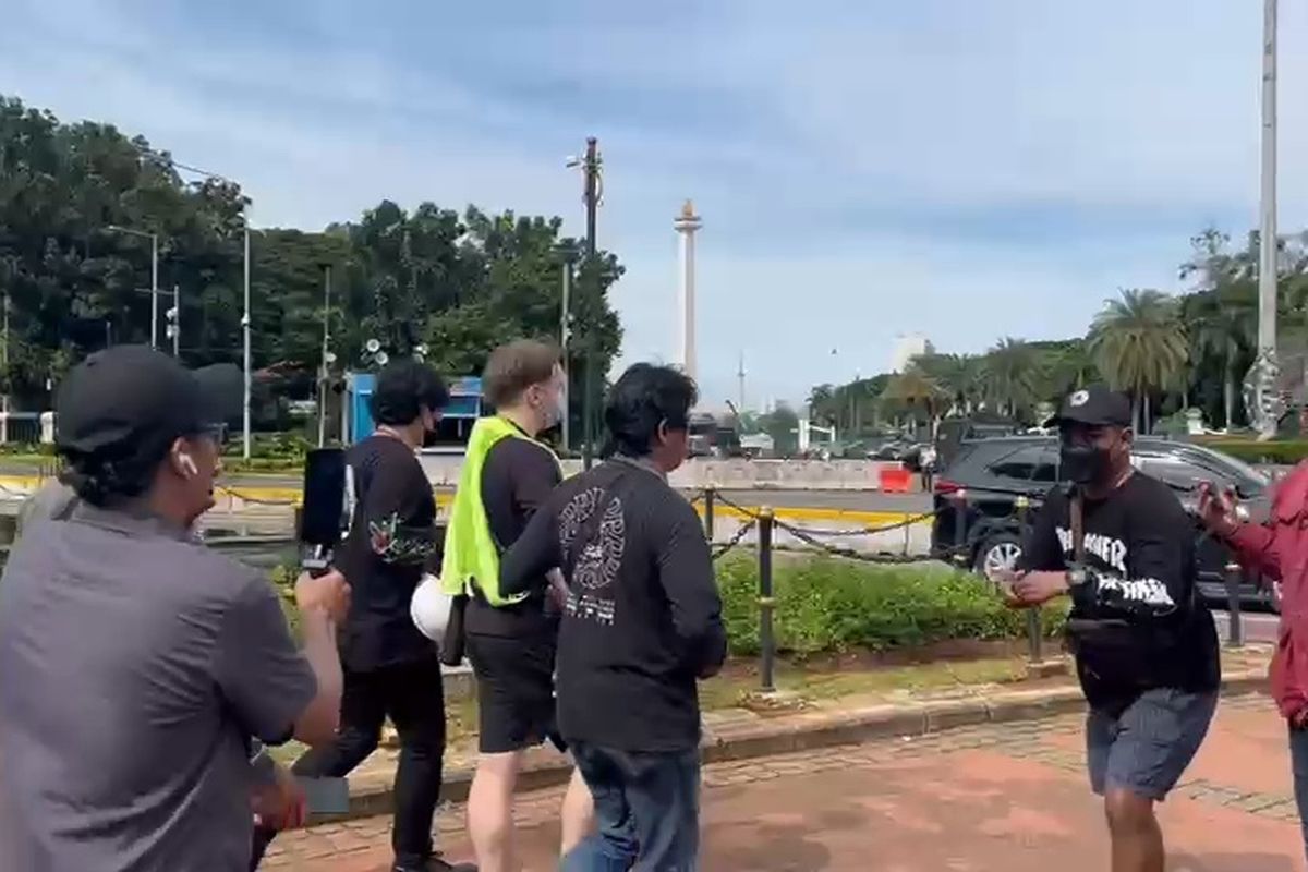 Seorang warga negara asing (WNA) digiring saat mengambil gambar sejumlah mahasiswa yang tengah berdemonstrasi Indonesia Gelap di Patung Kuda Arjuna Wijaya, Gambir, Jakarta Pusat, Kamis (20/2/2025). 