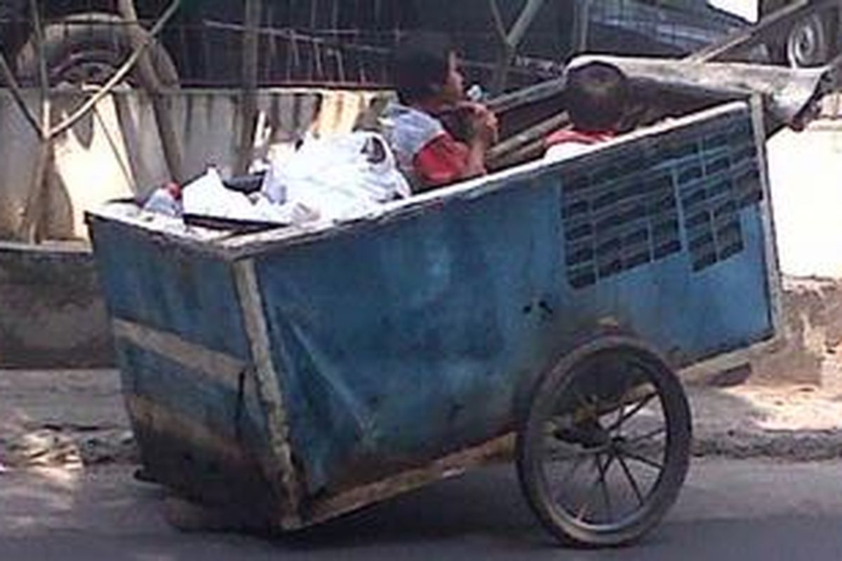 Dua orang anak yang mengikuti orangtua mereka mengumpulkan barang-barang bekas di wilayah Pejaten Barat, Jakarta Selatan, Selasa (24/7/2012). Mereka kerap disebut 