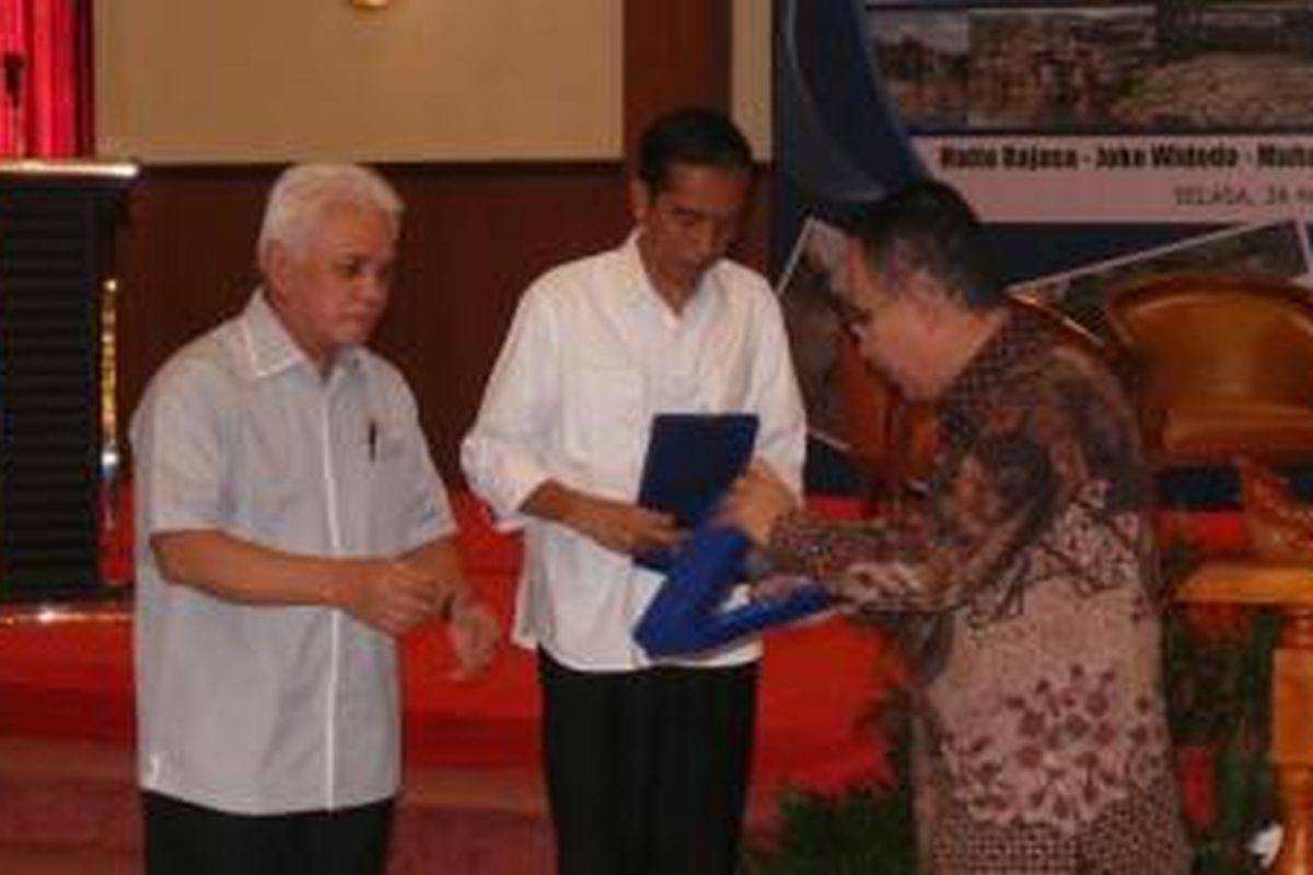 Menteri Koordinator Perekonomian Hatta Radjasa dan Gubernur Jakarta Joko Widodo mendapat plakat saat hadir dalam diskusi publik soal banjir yang digelar di Universitas Indonesia.