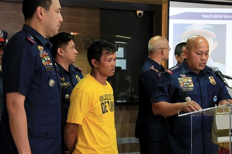 Foto yang dirilis Kepolisian Nasional Filipina pada Senin (5/3/2018), menunjukkan tersangka anggota ISIS, Nasser Lomondot (baju kuning) yang ditangkap di Manila.
