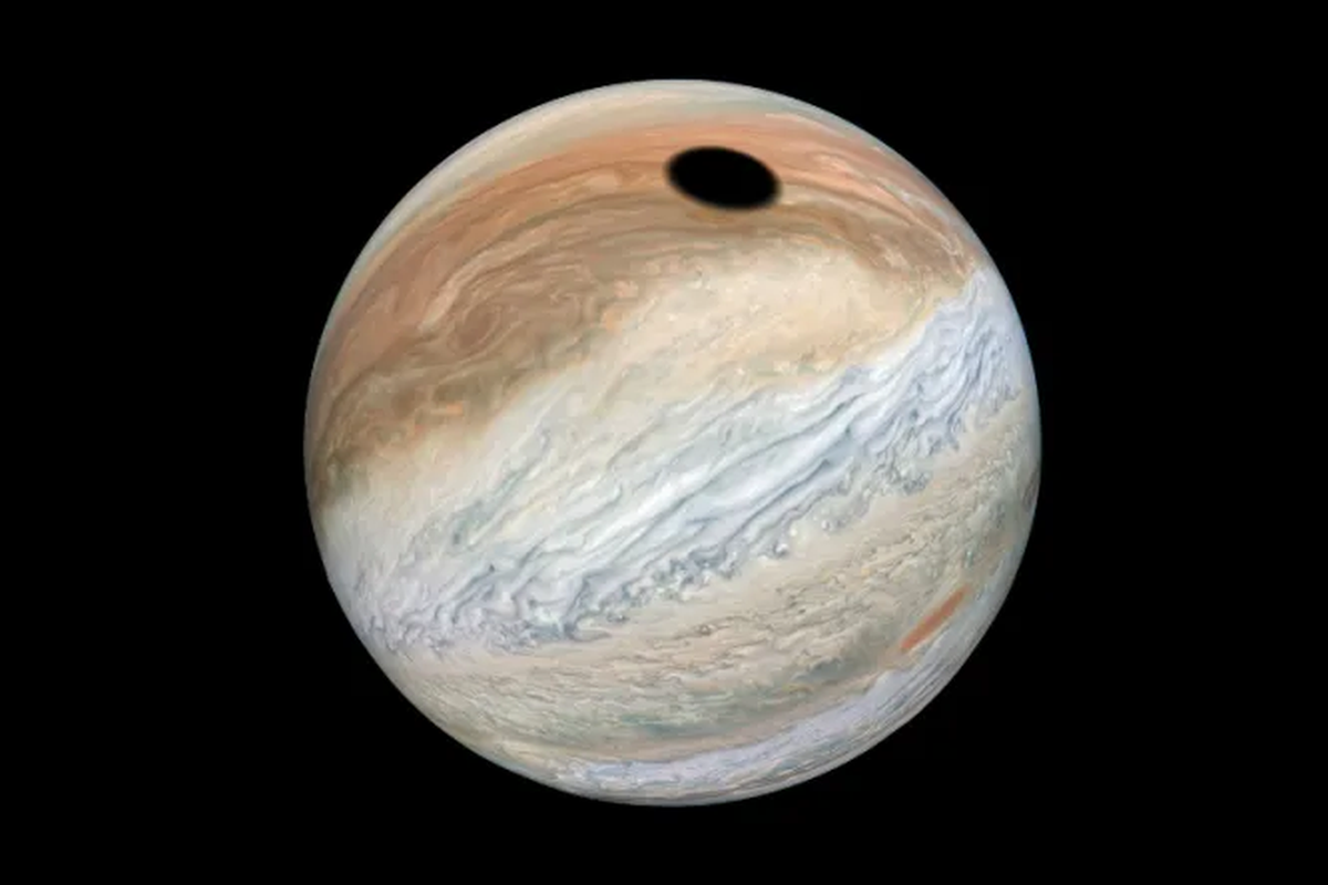 Rupa Jupiter ditangkap wahana nirawak milik NASA, Juno, pada (12/9/2019). Lingkaran hitam itu adalah bayangan bulan Jupiter, Io.