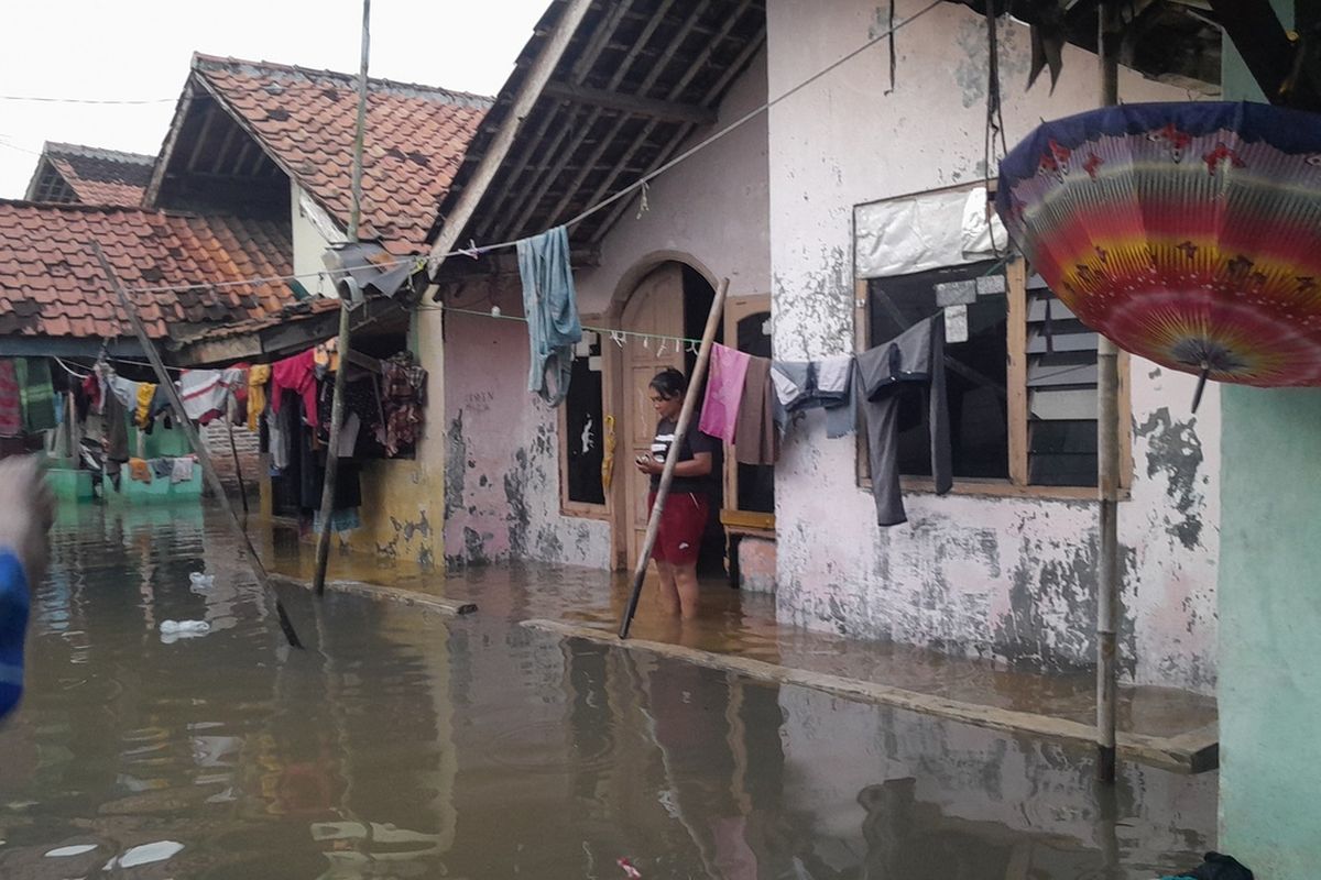 Warga Kampung Buniagaseuri, Kelurahan Tanjungmekar, Kecamatan Karawang Barat, Kabupaten Karawang, Jawa Barat beraktivitas saat banjir melanda kampungnya, Jumat (24/2/2023).