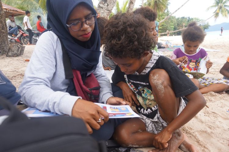 Fauzhya (berkacamata) sedang mengajar membaca di salah satu distrik di Fakfak, Papua Barat.