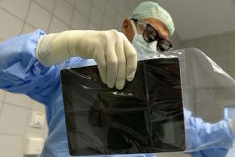 iPad dimasukkan ke plastik steril sebelum operasi dimulai