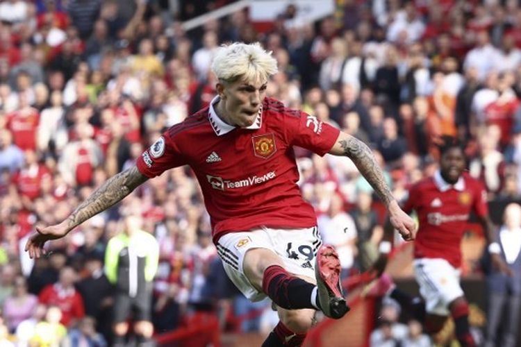 Pemain sayap Manchester United, Alejandro Garnacho, mencetak gol ke gawang Wolves pada laga lanjutan Liga Inggris 2022-2023. Laga Man United vs Wolves pada pekan ke-36 yang digelar di Stadion Old Trafford pada Sabtu (13/5/2023) waktu setempat itu berakhir dengan kemenangan 2-0 Man United. (Foto oleh DARREN STAPLES/AFP)