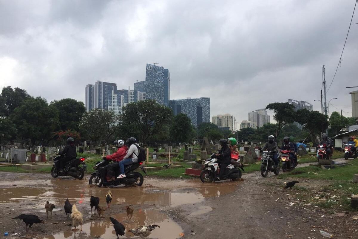 beberapa pengendara motor melewati pemakaman Menteng Pulo, Jakarta Selatan, Kamis (20/2/2020)